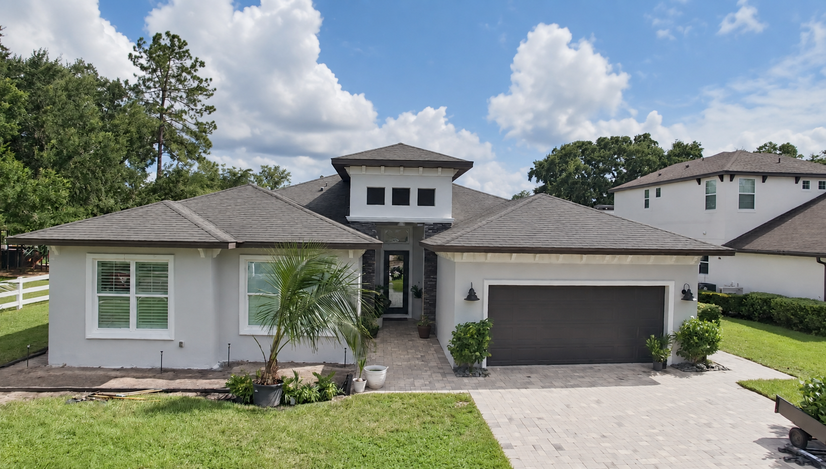 Completed Central Florida residential exterior painting with light walls and dark garage accents